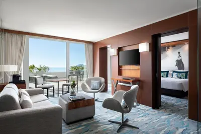 a living room with a couch and a room with a bed at JW Marriott Cannes in Cannes