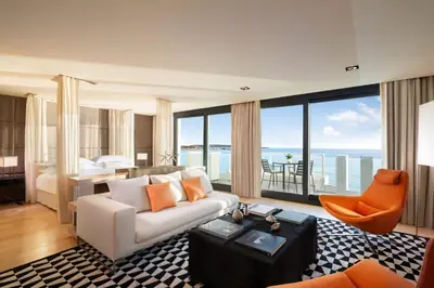 a bedroom with a large white bed and a desk at JW Marriott Cannes in Cannes