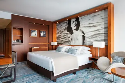 a bedroom with a bed with a large painting on the wall at JW Marriott Cannes in Cannes
