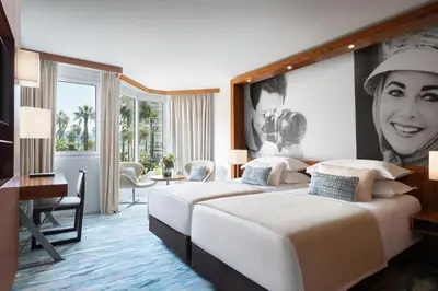 a hotel room with two beds and a picture of a woman at JW Marriott Cannes in Cannes