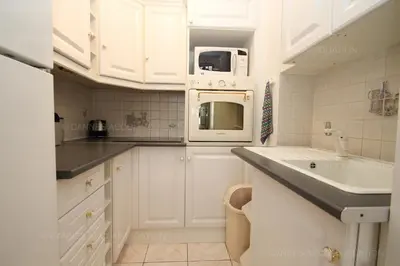 a white kitchen with a sink and a microwave at Jonquille in Cannes