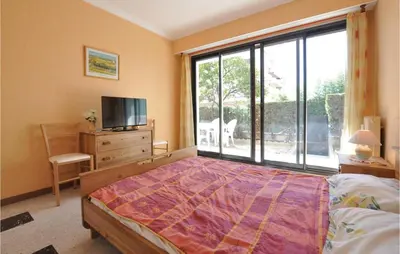 a bedroom with a bed and a large window at Nice Apartment In Le Cannet With Wifi in Le Cannet