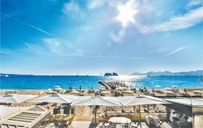a beach with chairs and umbrellas and the ocean at Nice Apartment In Le Cannet With Wifi in Le Cannet