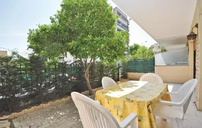 a table and chairs on a patio with a tree at Nice Apartment In Le Cannet With Wifi in Le Cannet