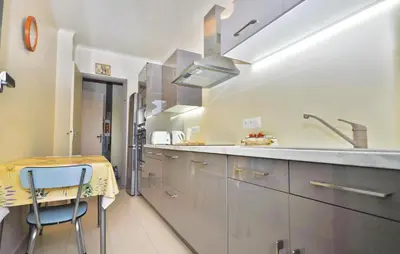 a kitchen with a sink and a table with a stool at Nice Apartment In Le Cannet With Wifi in Le Cannet