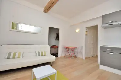 a living room with a white couch and a table at One bedroom apartment Palais des festivals in Cannes