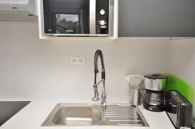a kitchen counter with a sink and a microwave at One bedroom apartment Palais des festivals in Cannes