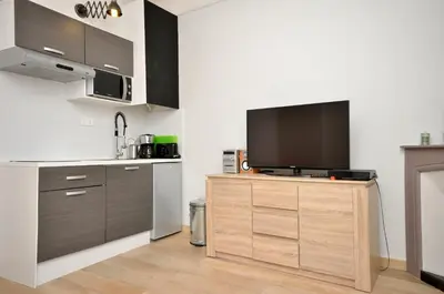 a kitchen with a flat screen tv on a wooden cabinet at One bedroom apartment Palais des festivals in Cannes