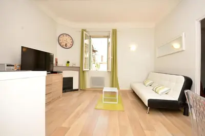 a living room with a couch and a clock on the wall at One bedroom apartment Palais des festivals in Cannes