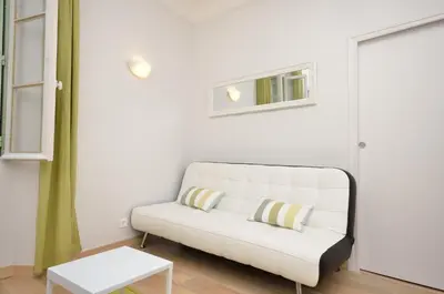 a living room with a white couch and a table at One bedroom apartment Palais des festivals in Cannes