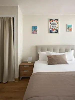 a bedroom with a large bed and a window at Hotel des Congrès et Festivals in Cannes