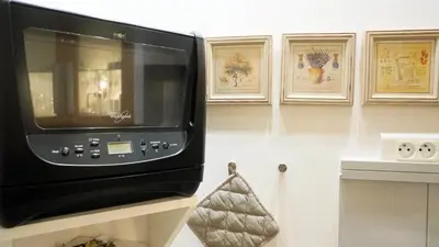a microwave sitting on a shelf in a kitchen at Proche Croisette, Studio Cosy by Palmazur in Cannes
