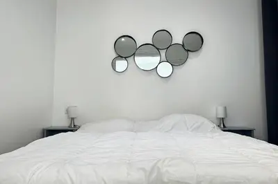 a bedroom with a bed with three mirrors on the wall at Charming 2-bedroom apartment with quality amenities in Old Cannes in Cannes