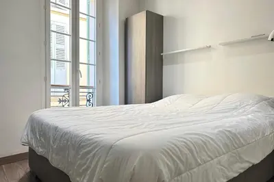 a white bed in a room with a window at Charming 2-bedroom apartment with quality amenities in Old Cannes in Cannes