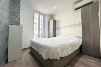 a bedroom with a bed and a large window at Charming 2-bedroom apartment with quality amenities in Old Cannes in Cannes