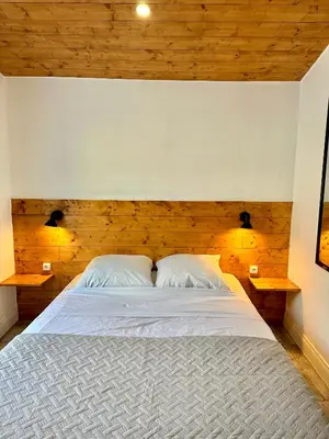 a bedroom with a large white bed with wooden walls at Lion's Room - 2 minute walk from Palais des Festivals and Beaches in Cannes