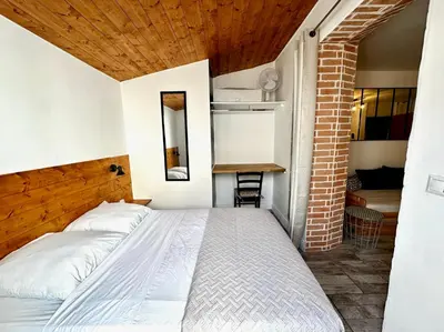 a bedroom with two beds and a brick wall at Lion's Room - 2 minute walk from Palais des Festivals and Beaches in Cannes