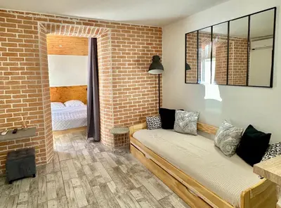 a living room with a couch and a brick wall at Lion's Room - 2 minute walk from Palais des Festivals and Beaches in Cannes