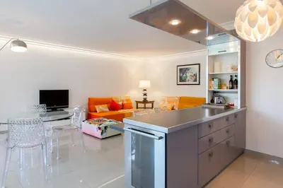 a kitchen and living room with an orange couch at MARTINEZ HOTEL AREA: Modern 3 bedrooms w/ terrace in Cannes