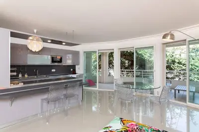 a kitchen and dining room with a glass table and chairs at MARTINEZ HOTEL AREA: Modern 3 bedrooms w/ terrace in Cannes