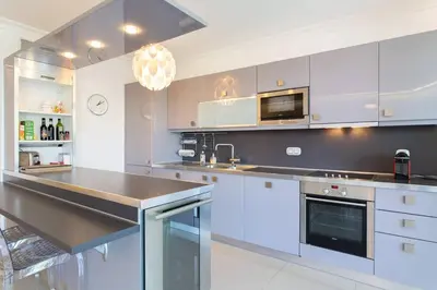 a kitchen with white cabinets and a black counter top at MARTINEZ HOTEL AREA: Modern 3 bedrooms w/ terrace in Cannes