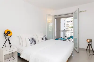 a white bedroom with a large bed and a balcony at MARTINEZ HOTEL AREA: Modern 3 bedrooms w/ terrace in Cannes