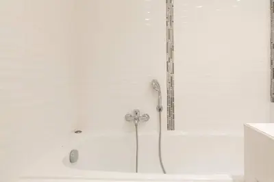 a white bath tub with a shower in a bathroom at MARTINEZ HOTEL AREA: Modern 3 bedrooms w/ terrace in Cannes