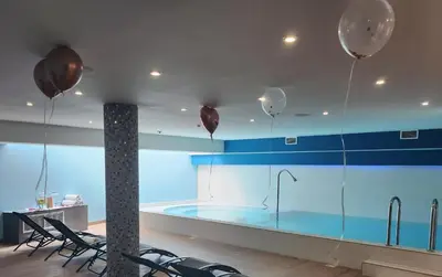 a swimming pool in a room with balloons on the ceiling at Hôtel Montaigne & Spa - Cannes Centre in Cannes