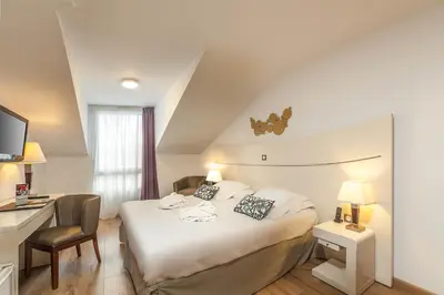 a hotel room with a bed and a desk at Hôtel Montaigne & Spa - Cannes Centre in Cannes