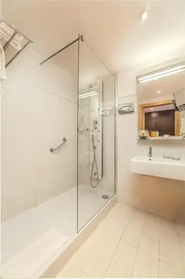 a bathroom with a glass shower and a sink at Hôtel Montaigne & Spa - Cannes Centre in Cannes
