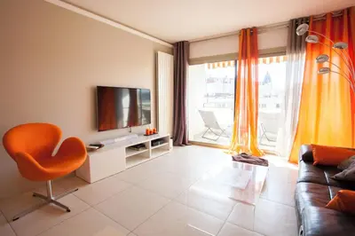 a living room with a couch and a television at Modern two bedroom apartment with two bathrooms, just behind the CARLTON in Cannes