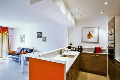 a kitchen with a sink and a living room at Modern two bedroom apartment with two bathrooms, just behind the CARLTON in Cannes