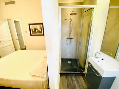 a bathroom with a shower and a bed and a sink at Cozy 2 bedroom apartment in the centre of Cannes near the CROISETTE in Cannes