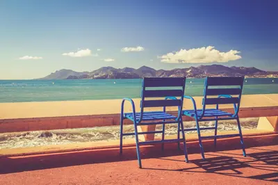 two blue chairs sitting on a wall near the beach at Cozy 2 bedroom apartment in the centre of Cannes near the CROISETTE in Cannes