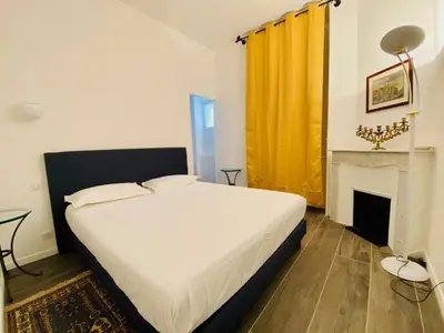 a bedroom with a white bed and a fireplace at Cozy 2 bedroom apartment in the centre of Cannes near the CROISETTE in Cannes