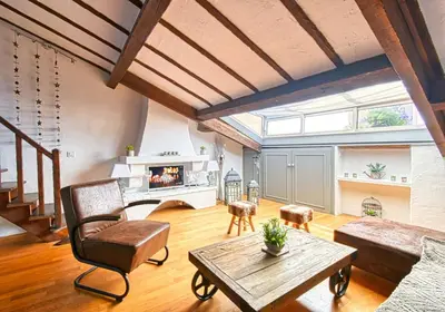 a living room with a fireplace and a table at LE BOISE merveilleux duplex rustique, excellent emplacement à quelques pas du Palais in Cannes