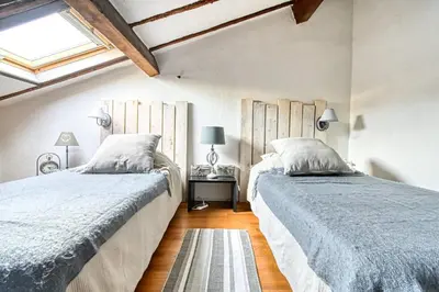 a bedroom with two beds and a window at LE BOISE merveilleux duplex rustique, excellent emplacement à quelques pas du Palais in Cannes