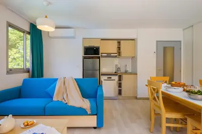 a living room with a blue couch and a kitchen at Résidence Villa Livia in Cannes