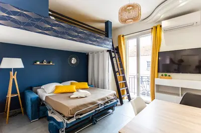 a bedroom with a bed with a blue wall at Relaxhome - Hypercentre - Clim - Netflix in Cannes