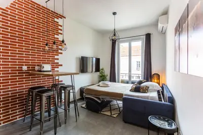 a bedroom with a bed and a brick wall at Relaxhome - Hypercentre - Clim - Netflix in Cannes