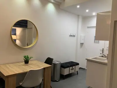 a kitchen with a table and a mirror on the wall at Relaxhome - Hypercentre - Clim - Netflix in Cannes