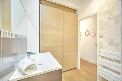 a bathroom with a white sink and a shower at Cannes Carré d'Or Cozy 1 BR balcony, Croisette Palais 2 mn by Olam Properties in Cannes