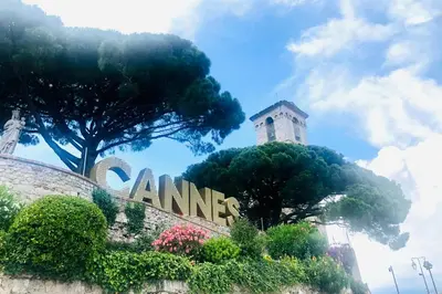 a sign in front of a building with a tower at Cannes Carré d'Or Cozy 1 BR balcony, Croisette Palais 2 mn by Olam Properties in Cannes
