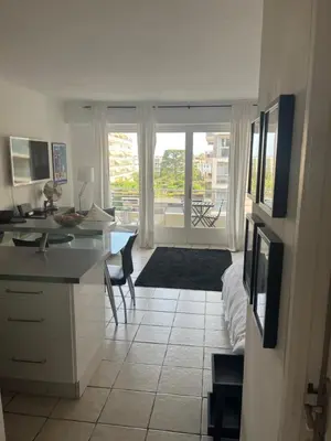 a room with a kitchen with a desk and a bed at Trianon Palace in Cannes