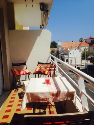 a balcony with a table and chairs on a balcony at Trianon Palace in Cannes