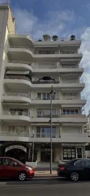 a large white building with cars parked in front of it at Trianon Palace in Cannes