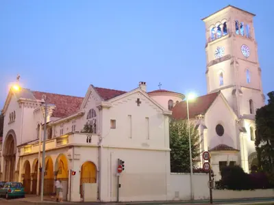 a church with a clock tower on a street at Trianon Palace in Cannes