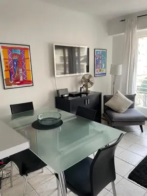 a living room with a glass table and chairs at Trianon Palace in Cannes
