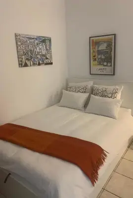 a bedroom with a large white bed with two pictures on the wall at Trianon Palace in Cannes
