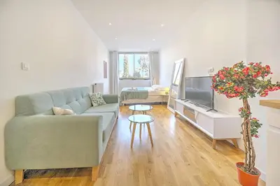 a living room with a couch and a tv at Cannes Heart of town Cozy bright warm & sunny studio by Olam Properties in Cannes